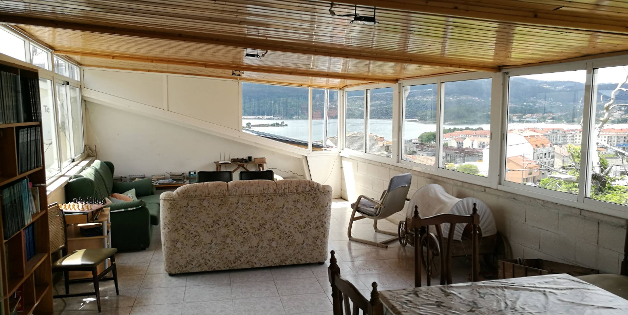 Common room with panoramic windows, sofas, chess set and town view