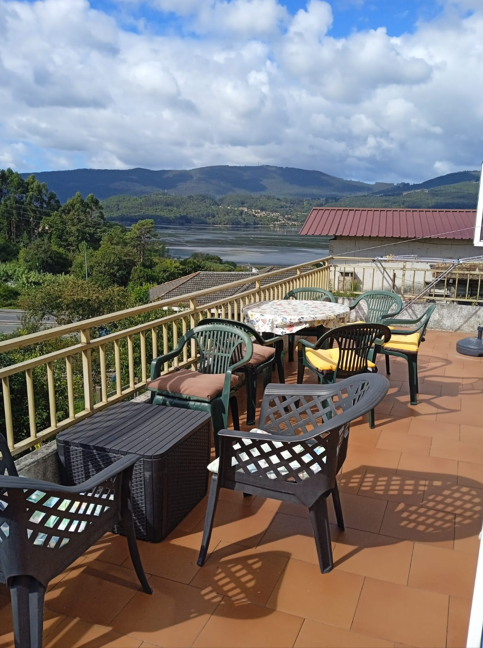 Terrace with outdoor seating overlooking mountains and Ría de Vigo